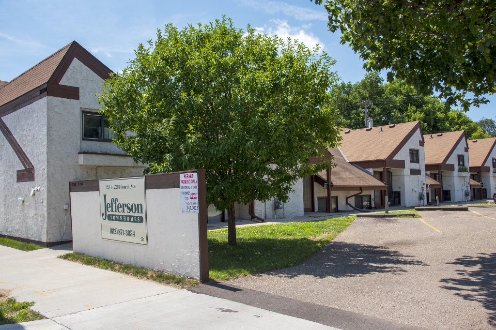 a group of houses in a neighborhood with a sign in front of it